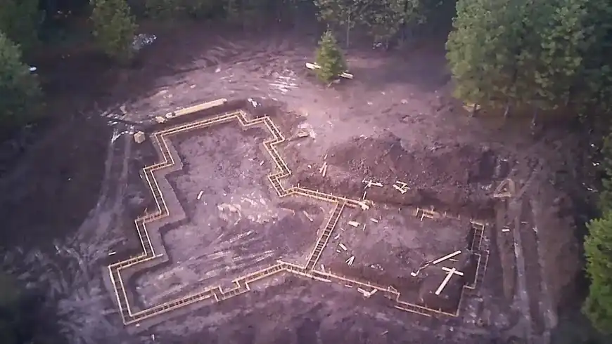 Drone view of footing forms laid out among pine trees