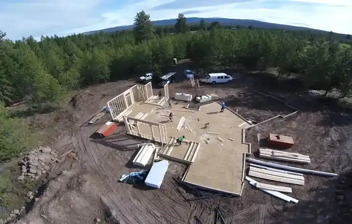 Drone view of a house at the framing stage on a lot in the pines