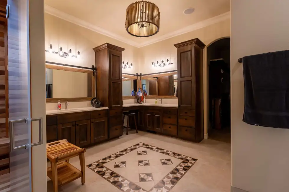 A dark-wood master bath vanity with a tile inlay floor