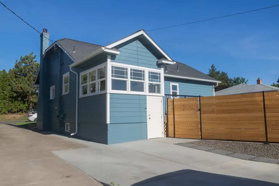 A blue-sided home with a driveway, finished by the Fisher Construction crew