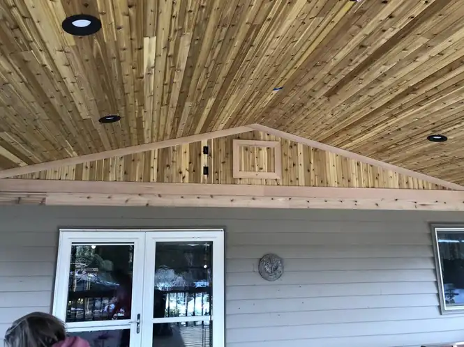 The cedar ceiling of a finished patio cover with recessed lights
