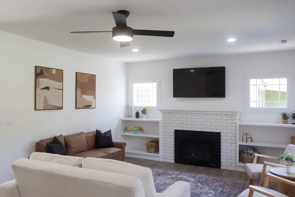A finished living room with a white brick fireplace